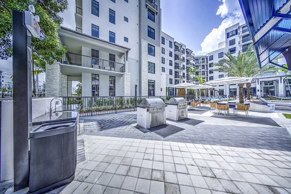 Outdoor grill area and patio at The Ellsworth Apartments, featuring modern seating and cooking facilities