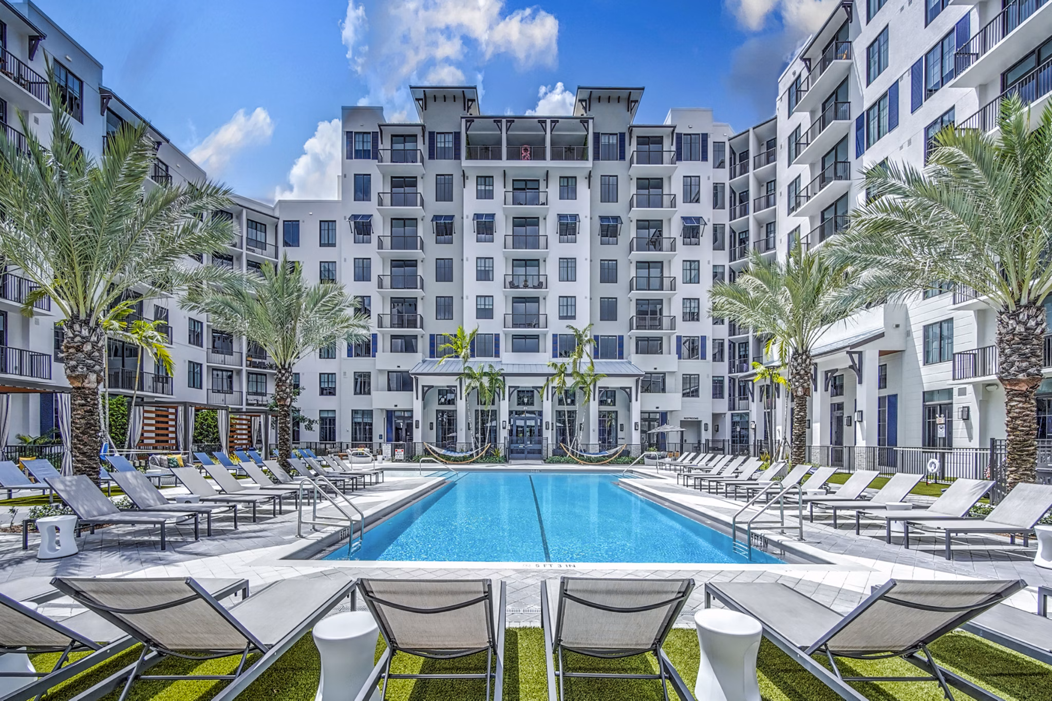 Resort-style pool with lounge seating at The Ellsworth Apartments