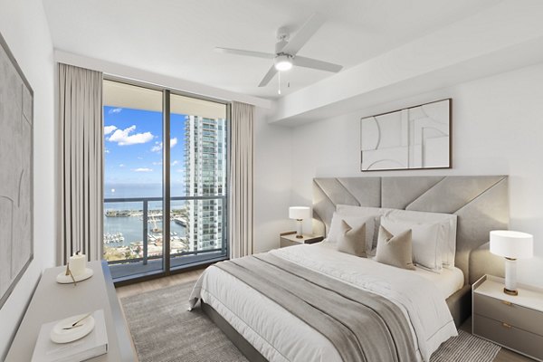 Cozy bedroom with modern decor in Ascent St Petersburg Apartments, featuring a queen bed and large windows for natural light