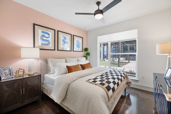 Elegant bedroom with plush bedding and modern decor at The Oliver Apartments