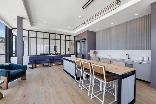 Clubhouse with modern decor and ample seating at The Oliver Apartments, ideal for social gatherings and community events