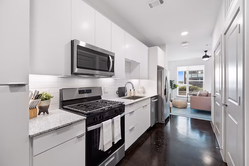 Modern kitchen with quartz countertops and stainless steel appliances at The Oliver Apartments