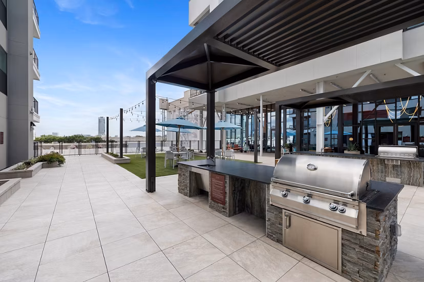 Outdoor grill area with stainless steel appliances at The Oliver Apartments, perfect for gatherings and cooking in style