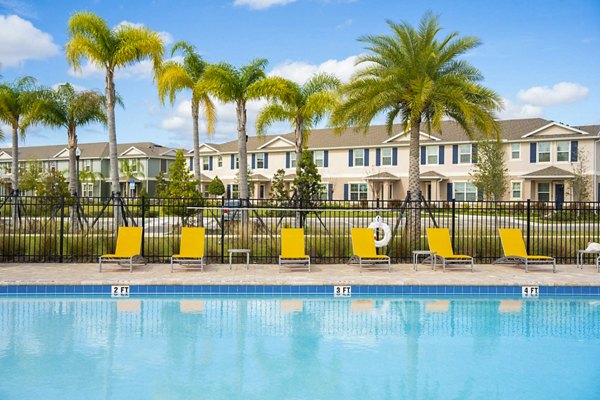 Resort-style pool at Summerwell Avian Pointe Apartments featuring lounging areas and lush landscaping