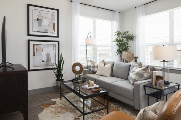 Living room with modern decor and large windows at Broadstone Bryson Apartments