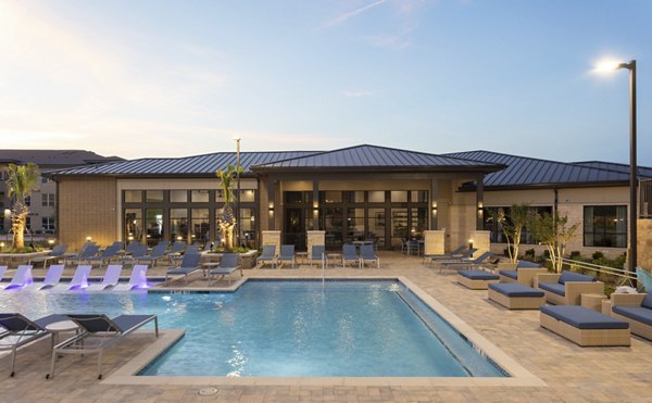 Broadstone Bryson Apartments: Luxury outdoor pool with lounge chairs and landscaped surroundings