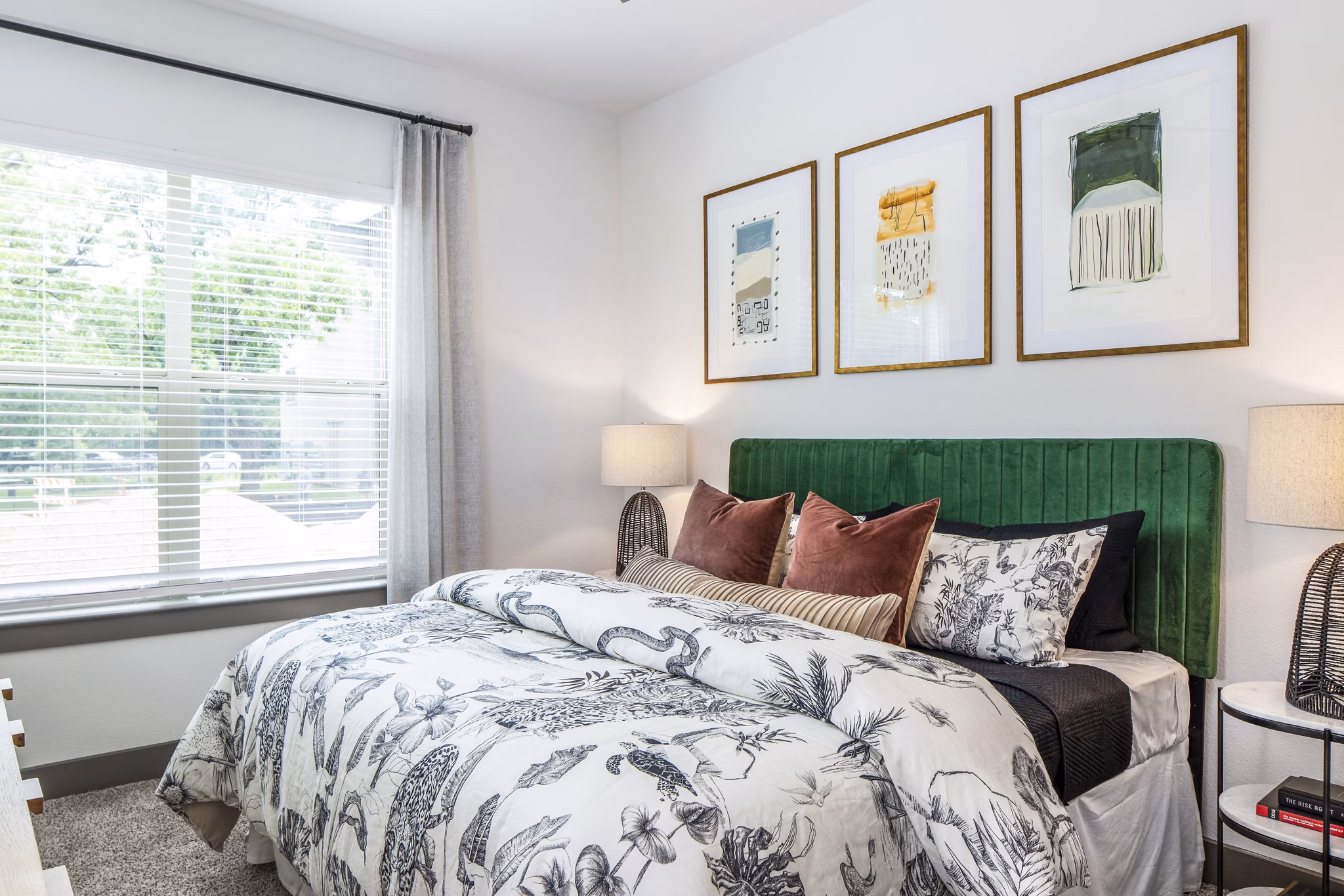 Spacious bedroom with decorative pillows and framed artwork in luxury apartment