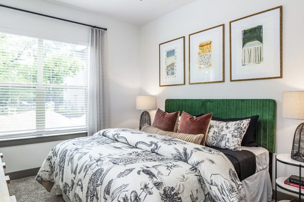 Spacious bedroom with decorative pillows and framed artwork in luxury apartment