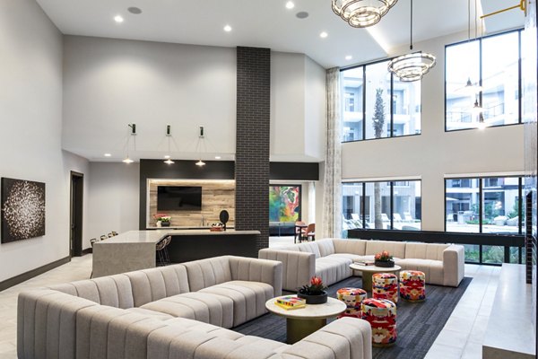 Spacious living area featuring a large sectional sofa and bar area in luxury apartment
