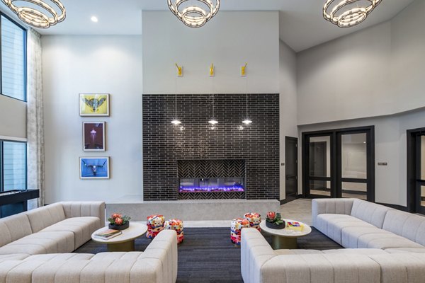 Modern living room with beige sofas, a black brick fireplace, and colorful artwork in luxury apartments