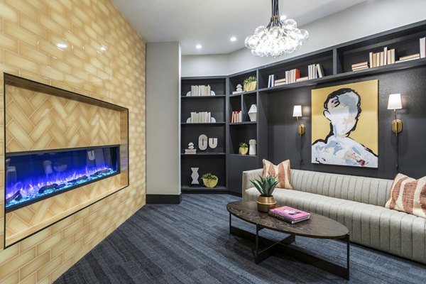 Modern living room with a sofa, coffee table, and wall-mounted fireplace in luxury apartment
