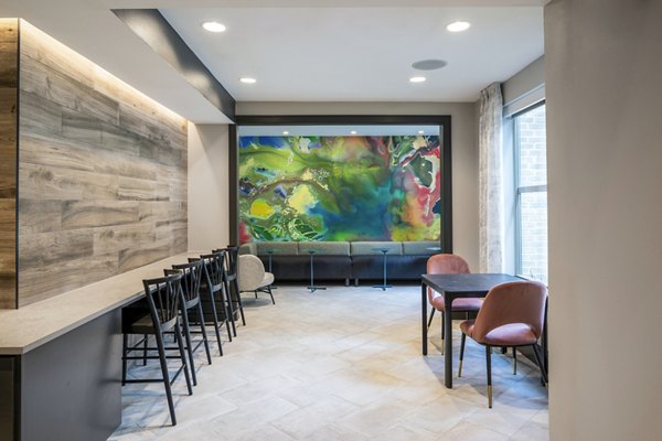 Modern interior seating area with tables, chairs, and vibrant abstract painting in luxury apartments