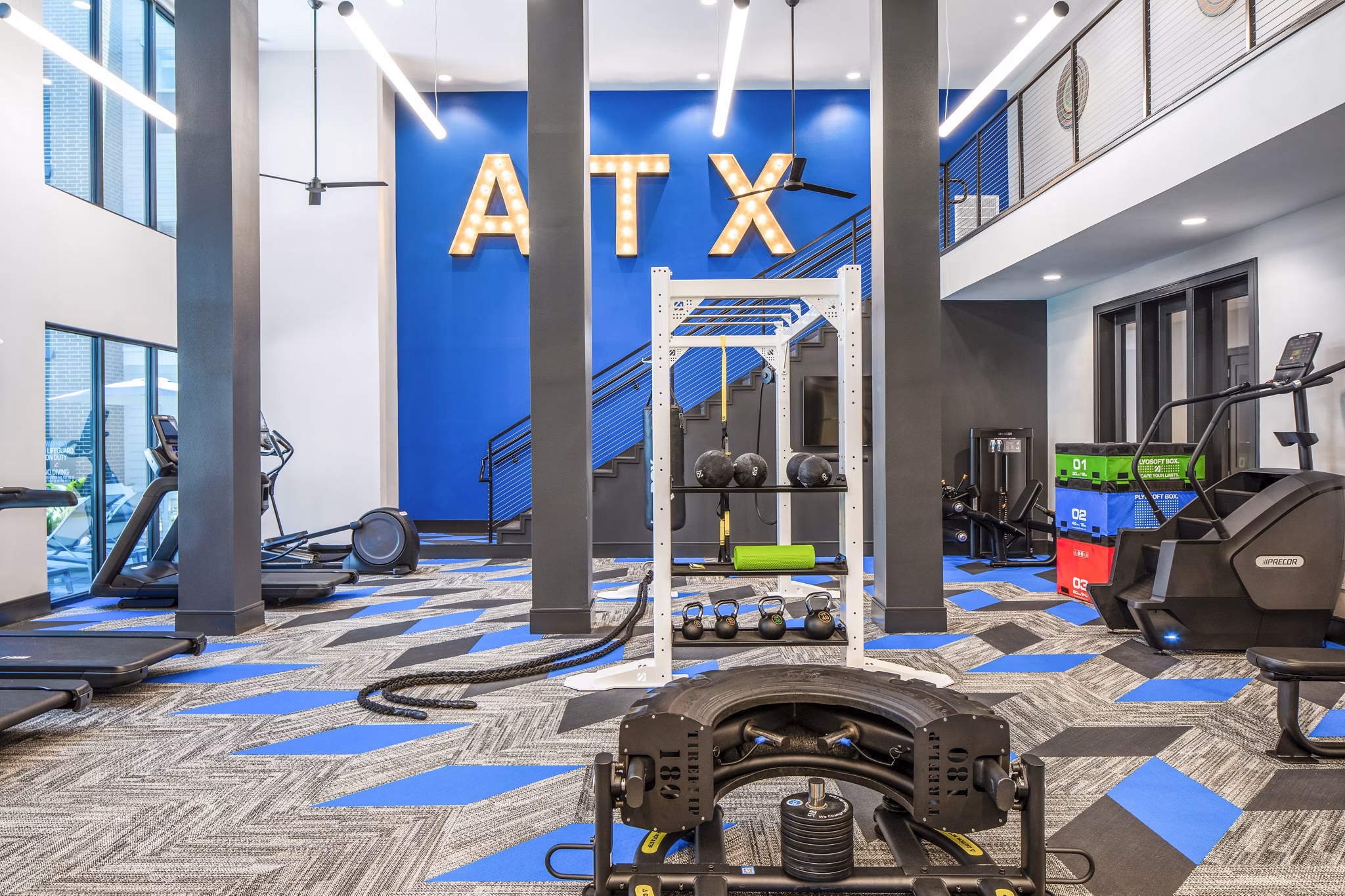 Modern gym featuring exercise equipment and ATX wall art at luxury apartments