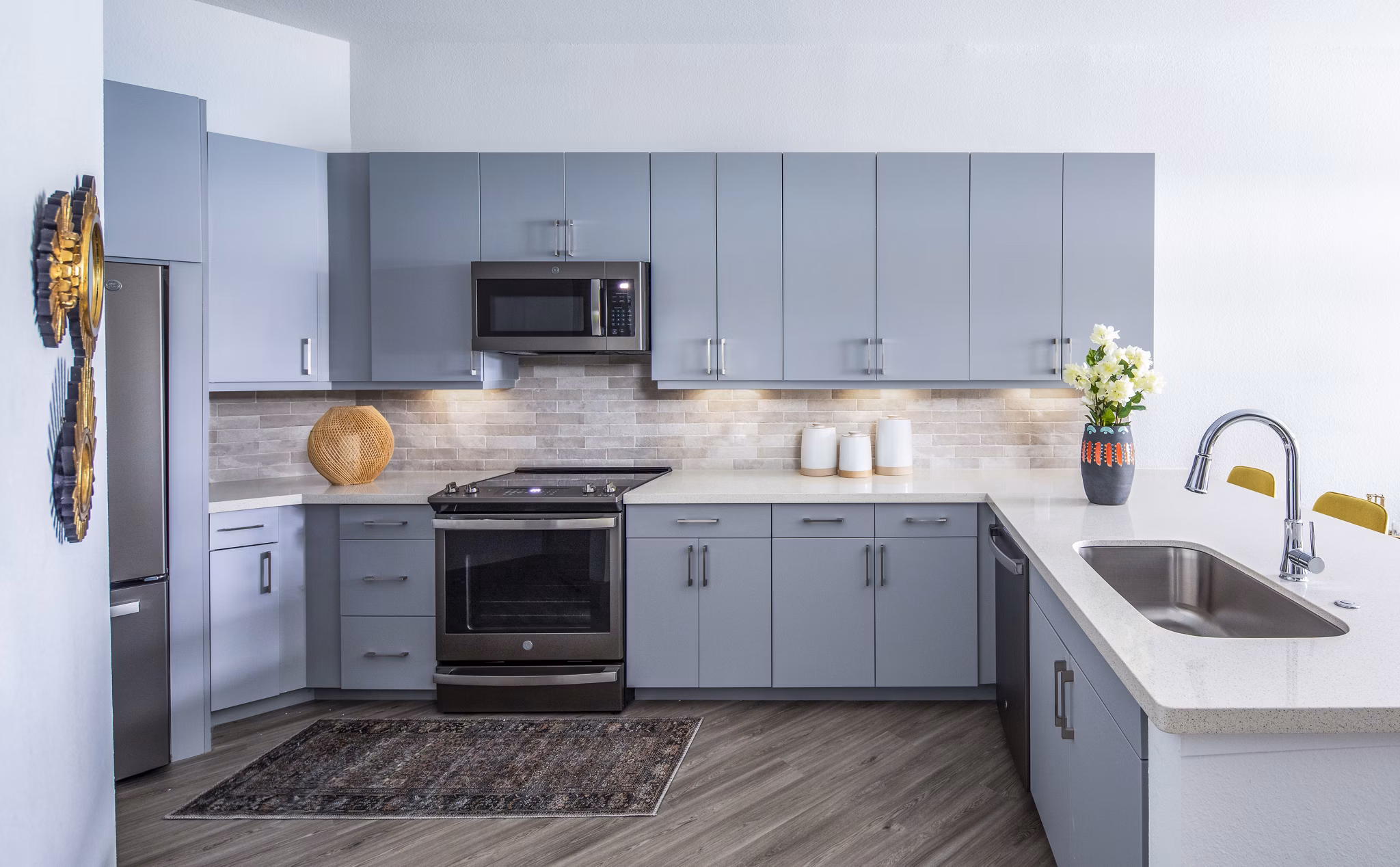 Modern kitchen with gray cabinets and stainless steel appliances in luxury apartments
