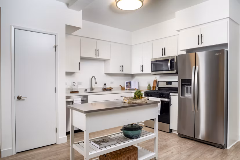 Modern kitchen with stainless steel appliances and island at Aston at Gateway Apartments