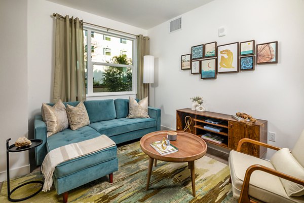 Modern living room with elegant furnishings at Aston at Gateway Apartments, featuring ample natural light