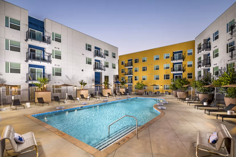 Aston at Gateway Apartments: Modern pool area with lounge chairs