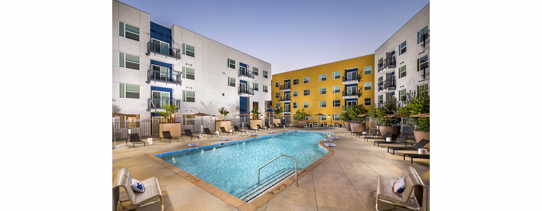 Aston at Gateway Apartments: Modern pool area with lounge chairs