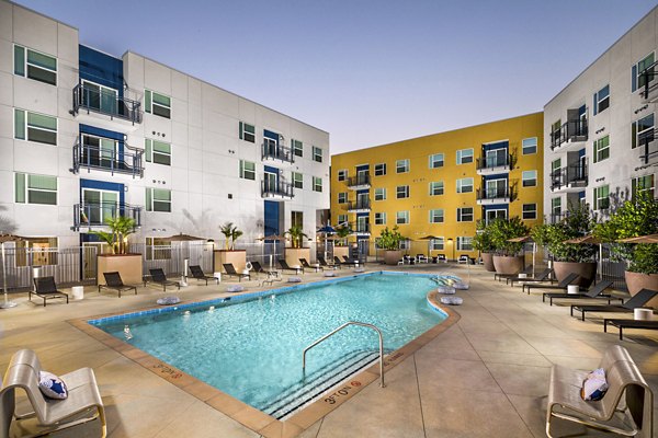 Aston at Gateway Apartments: Modern pool area with lounge chairs