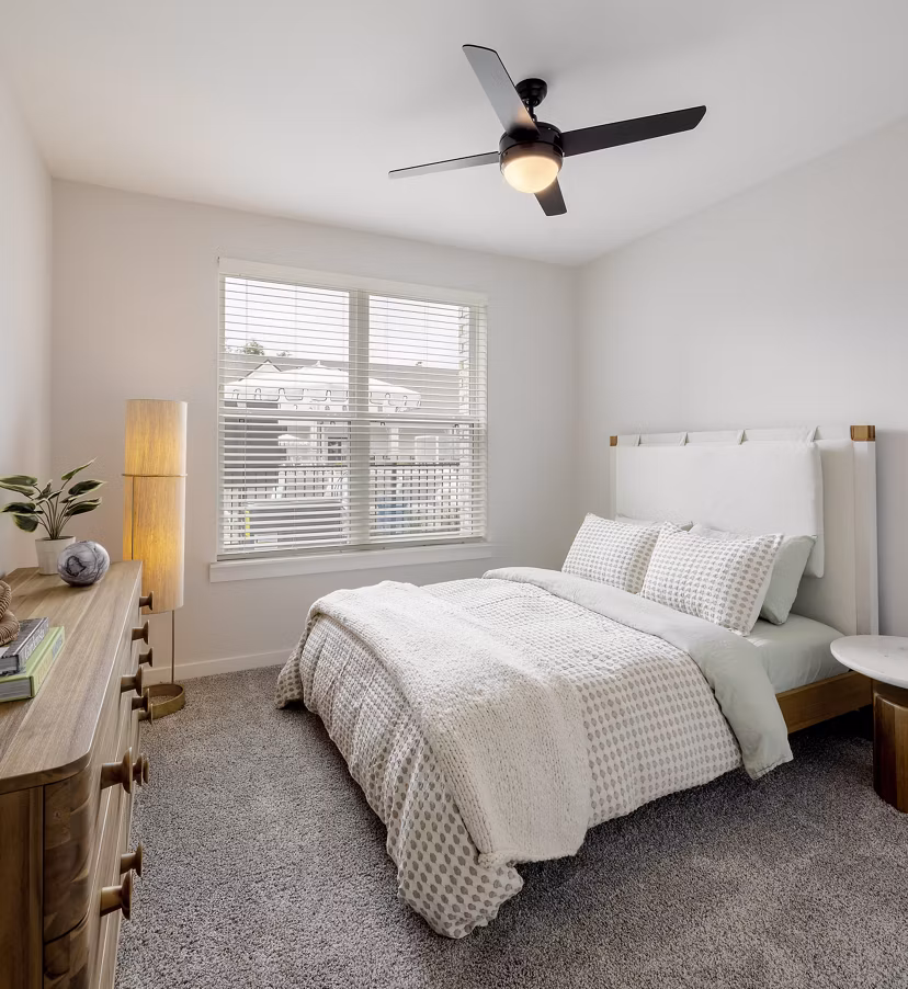 Elegantly furnished bedroom with large windows at Maxwell Apartments offering luxury living spaces