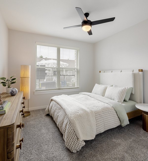 Elegantly furnished bedroom with large windows at Maxwell Apartments offering luxury living spaces