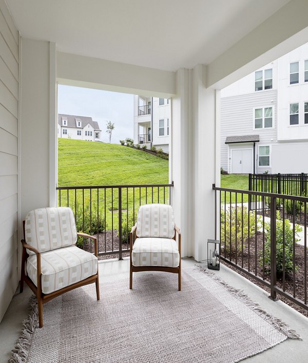 Spacious outdoor patio with seating and greenery at Maxwell Apartments, providing luxury relaxation space