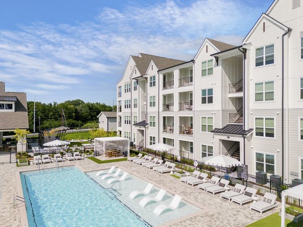Luxurious pool area with lounge chairs at Maxwell Apartments, perfect for relaxation and leisure activities in a vibrant community setting