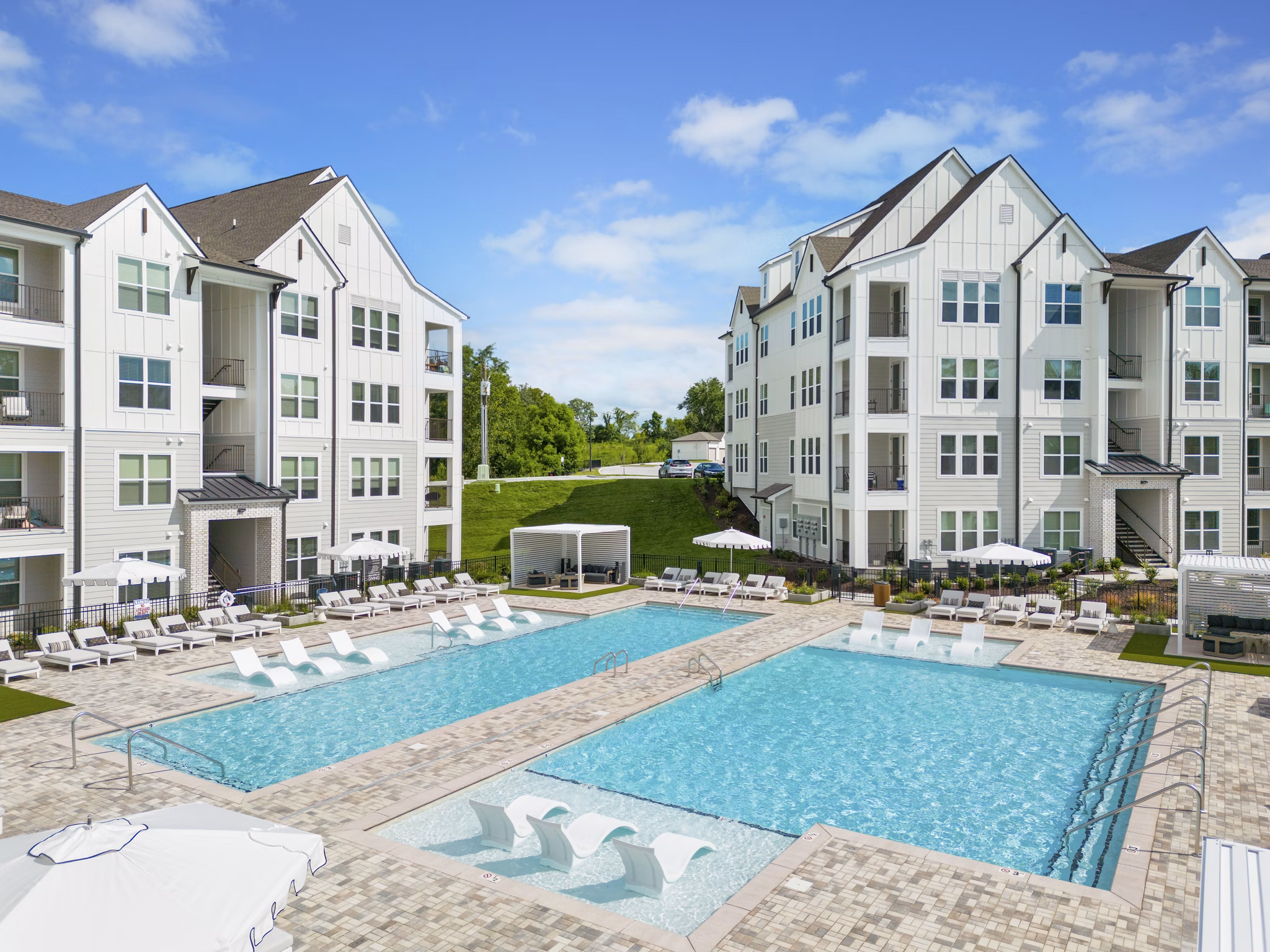 â€œLuxurious swimming pool area at Maxwell Apartments with lounge seatingâ€