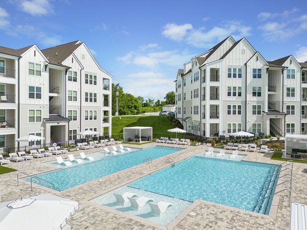 â€œLuxurious swimming pool area at Maxwell Apartments with lounge seatingâ€