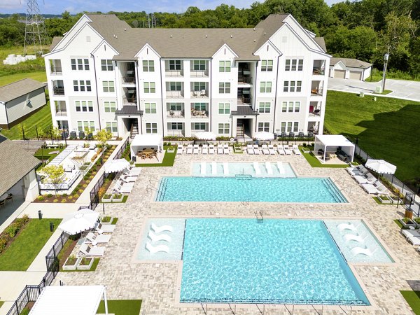 Elegant outdoor pool area at Maxwell Apartments with luxurious lounge chairs and scenic views