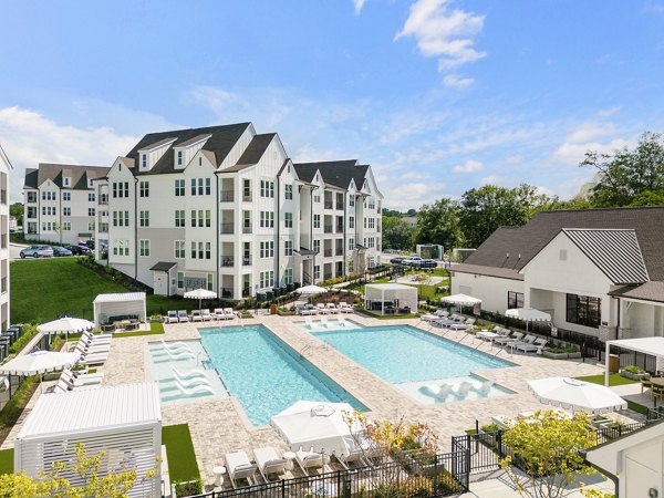 Outdoor pool with sun loungers at Maxwell Apartments offering leisure and relaxation for residents