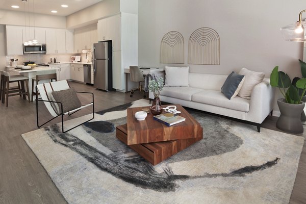 Spacious living room with modern decor and large windows in The Blake Apartments