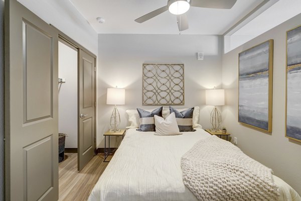 Spacious bedroom with tasteful decor at Novus Apartments, showcasing luxurious accommodations and modern design