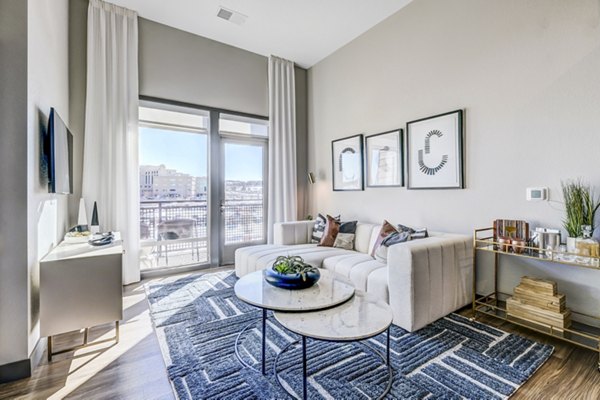 Spacious living room with modern furnishings and natural light at Novus Apartments