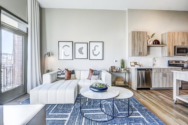 Stylish living room with modern furnishings and large windows in Novus Apartments