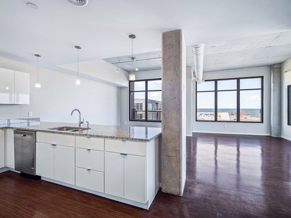 Modern kitchen with stainless steel appliances at The Flats at East Bank Homes, luxury living provided by Greystar