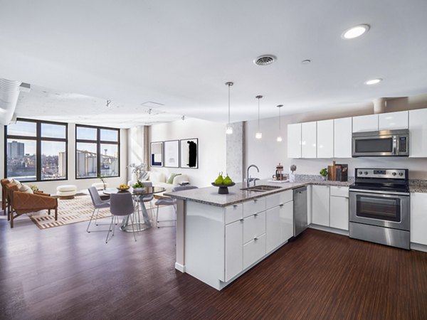Sleek kitchen with modern appliances and granite countertops at The Flats at East Bank Homes