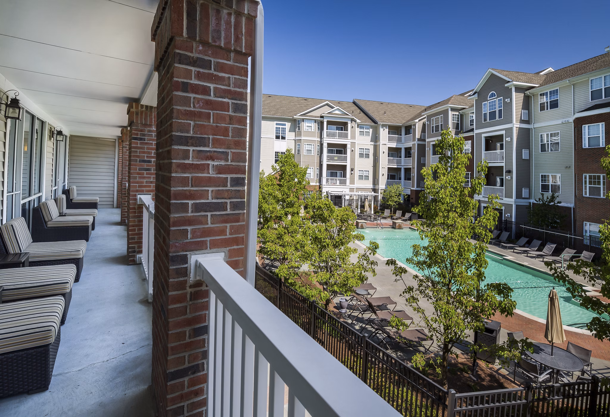 Spacious patio at The Avens Dedham Station Apartments featuring stylish outdoor seating and lush greenery