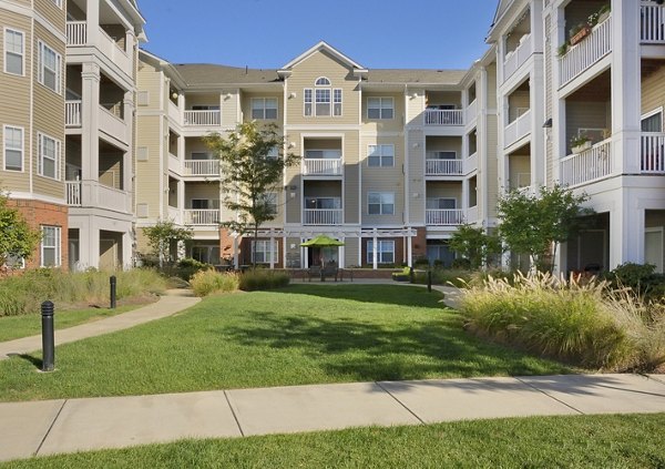 Courtyard with landscaped garden and seating area at The Avens Dedham Station Apartments