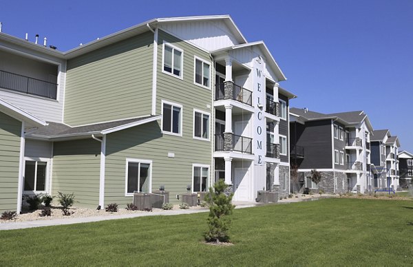 Millpond Apartments: Serene view of luxury apartments surrounded by lush greenery in a tranquil setting