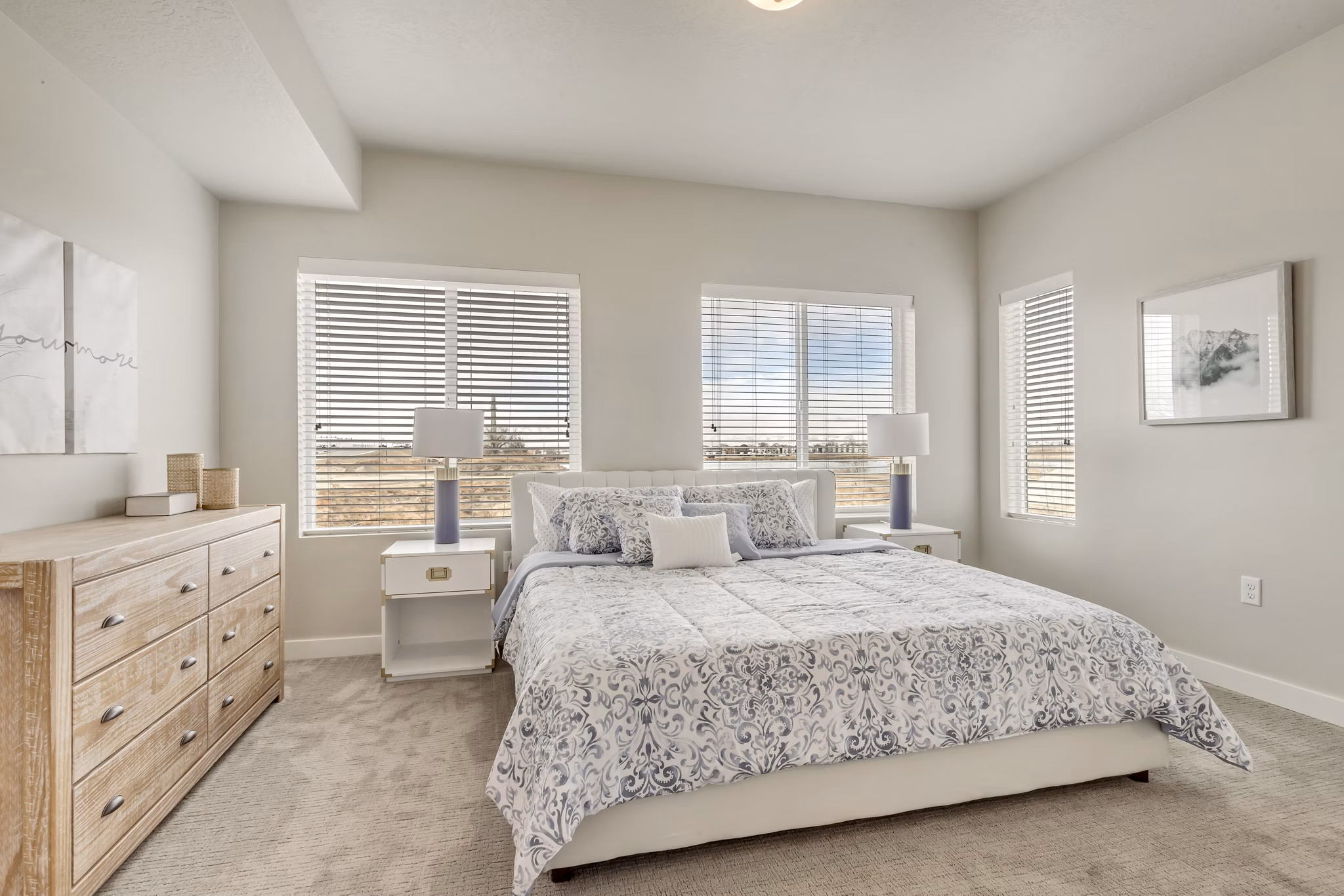 Spacious bedroom with large windows and modern furnishings at Millpond Apartments