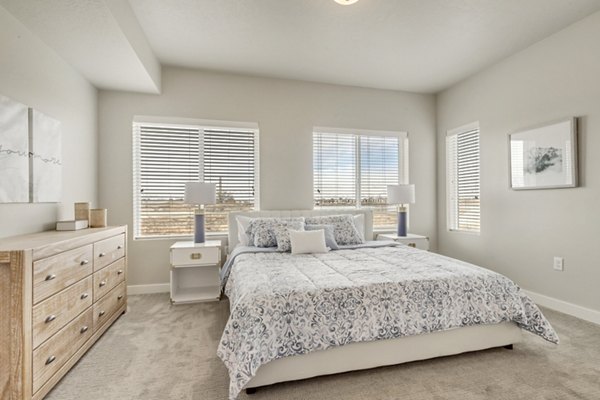 Spacious bedroom with large windows and modern furnishings at Millpond Apartments