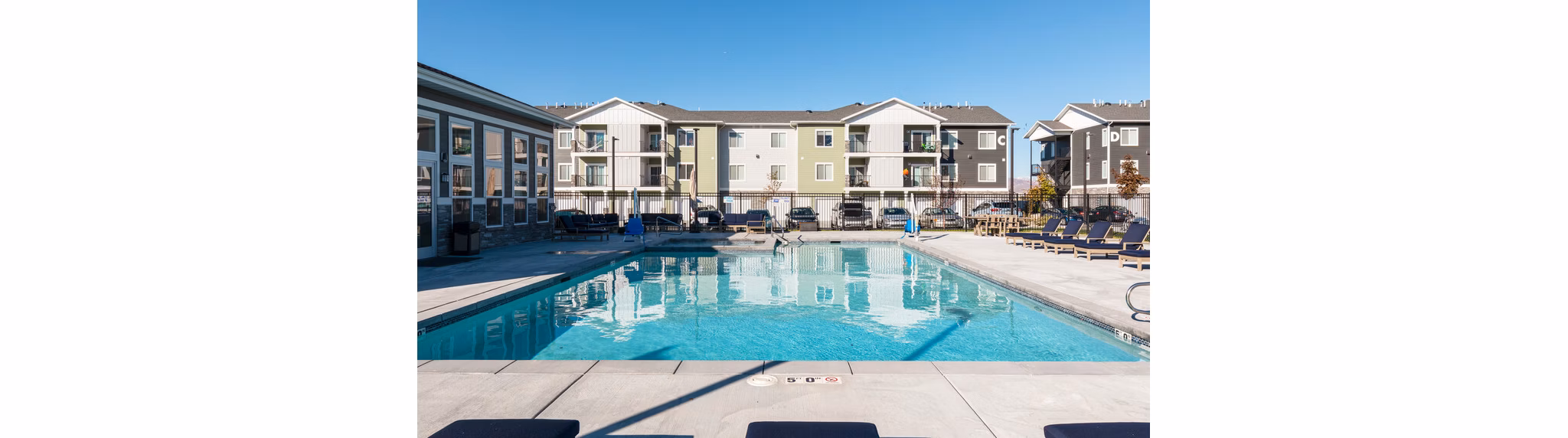 Sun-drenched pool with lounge chairs at Millpond Apartments, perfect for relaxation and recreation in a luxurious setting