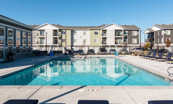 Sun-drenched pool with lounge chairs at Millpond Apartments, perfect for relaxation and recreation in a luxurious setting