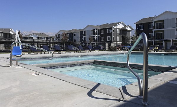 Modern pool with sun loungers and landscaped deck at Millpond Apartments