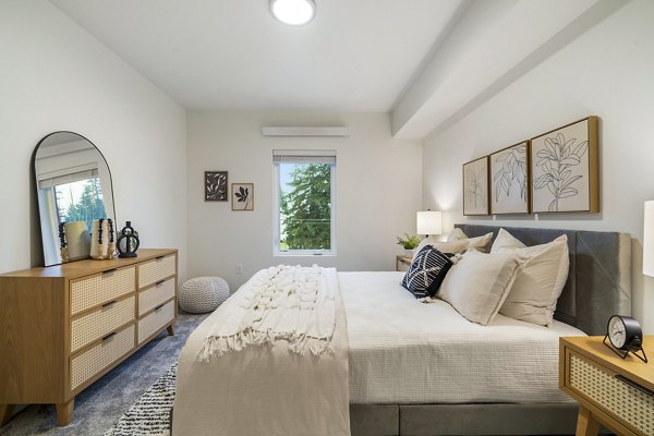 Cozy bedroom with plush bedding and modern decor at The Oliveen Apartments