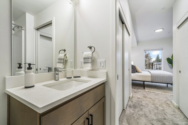 Modern bathroom with elegant fixtures at The Oliveen Apartments, featuring sleek cabinetry and marble countertops in a luxurious setting