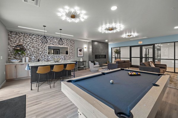 Clubhouse game room with pool table and TV lounge at The Oliveen Apartments