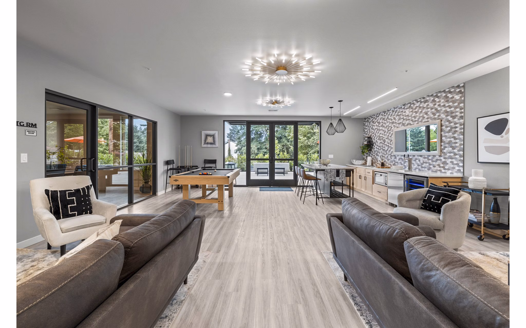 Clubhouse game room featuring pool table and comfy seating at The Oliveen Apartments