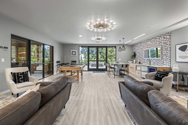 Clubhouse game room featuring pool table and comfy seating at The Oliveen Apartments